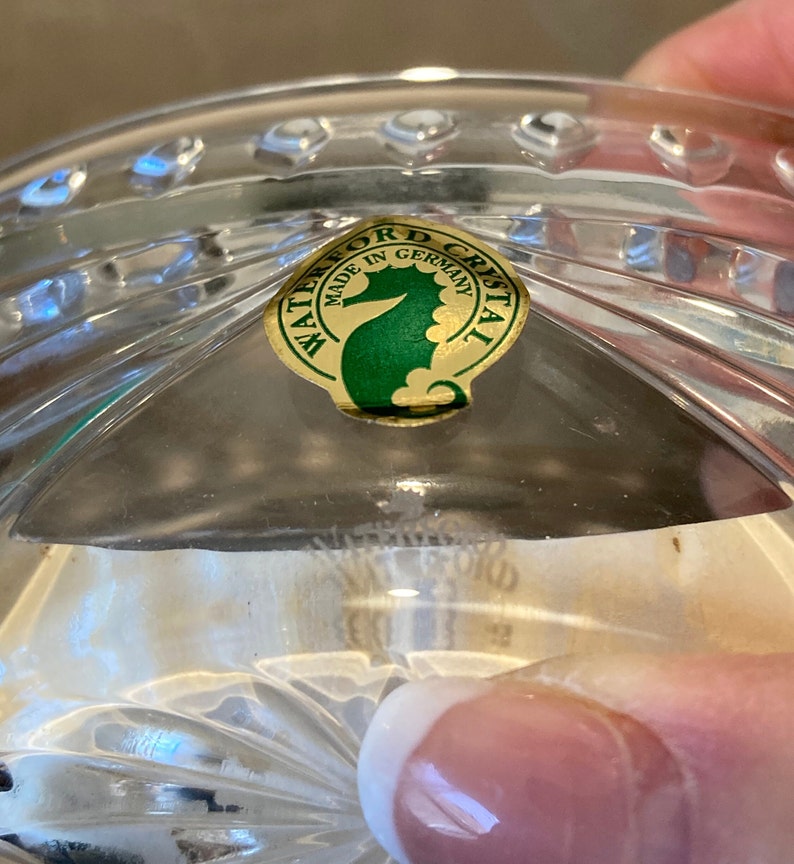 Puede incluir: Primer plano de una pegatina de Waterford Crystal con fondo dorado y logotipo de caballito de mar verde. La pegatina dice "Waterford Crystal Hecho en Alemania".
