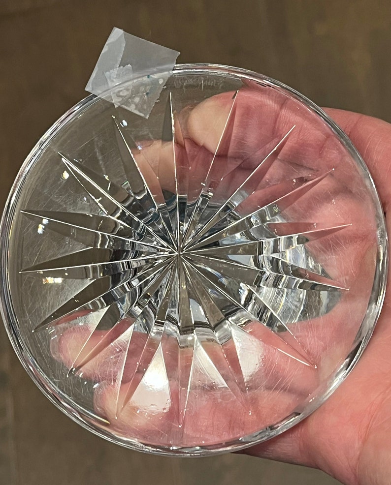 May include: The bottom of a clear crystal glass with a starburst pattern.
