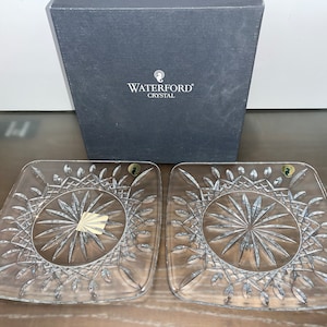 Pode incluir: Dois pratos quadrados de servir de cristal Waterford com um design de vidro cortado. Os pratos são transparentes e têm um padrão delicado.