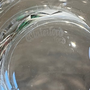 Peut inclure: Gros plan du fond d'un bol en verre transparent avec le mot "Waterford" grav&eacute; dans le verre.
