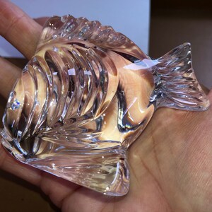 Peut inclure: Une figurine de poisson en verre transparent avec des d&eacute;tails complexes et une finition l&eacute;g&egrave;rement iris&eacute;e.