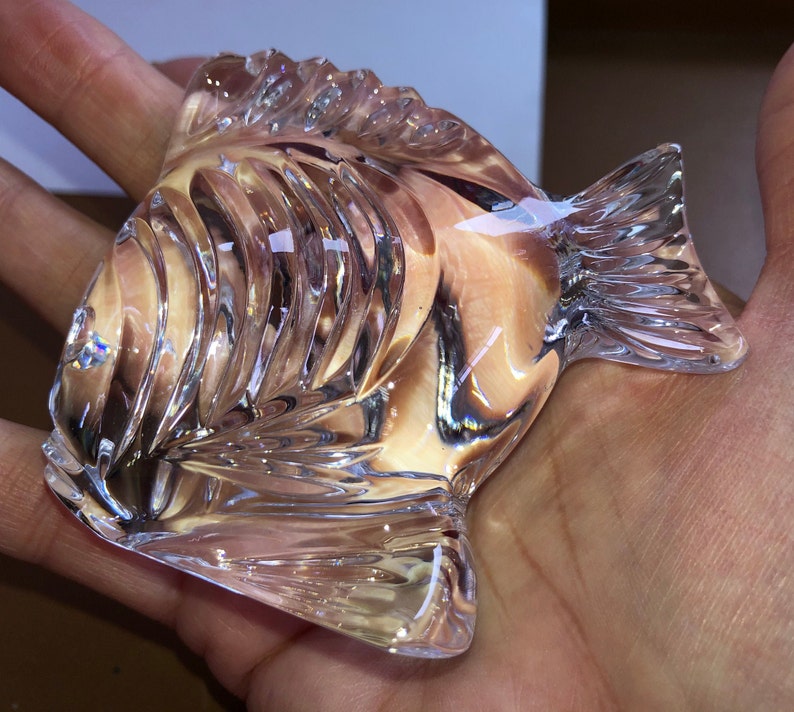 Peut inclure: Une figurine de poisson en verre transparent avec des d&eacute;tails complexes et une finition l&eacute;g&egrave;rement iris&eacute;e.