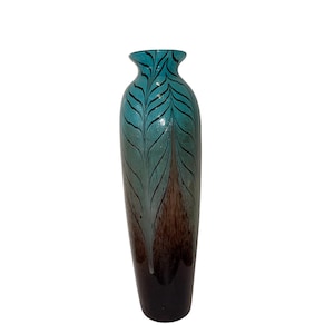 May include: A tall, decorative vase with a slender shape. The vase has a gradient of colours, starting with a teal top and transitioning to brown and black at the base. Black leaf-like patterns adorn the teal section.