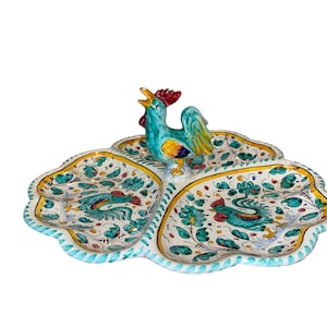 Puede incluir: Una taza de cerámica blanca con un asa negra y el texto "But First, Coffee" en negrita negra. La taza se encuentra sobre un fondo neutro, resaltando su diseño simple.