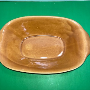 Op de afbeelding: Een bruine keramische bakvorm met een rechthoekige vorm en een licht verhoogd midden. De vorm heeft een geglazuurde afwerking en is ontworpen om te bakken en te serveren.