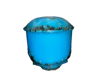 May include: A turquoise-blue, lidded jar with a rounded top and a cylindrical body. The rim and base feature a decorative, dark-colored trim. The jar has a glossy finish and is set against a white background.