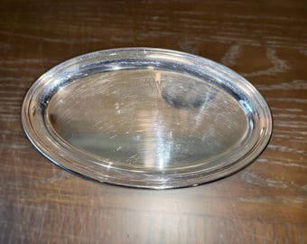 Könnte beinhalten: Ein silbernes, ovales Tablett mit einer glatten, reflektierenden Oberfläche.