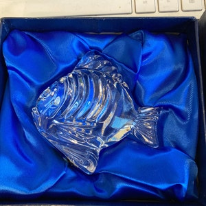 Peut inclure: Une figurine de poisson en verre transparent dans un coffret en velours bleu. Le poisson a un design d&eacute;taill&eacute; et est un objet d&eacute;coratif.