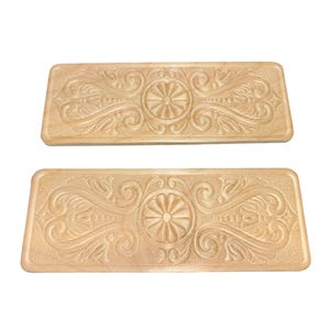 May include: Two rectangular, light-colored wooden decorative panels. Each panel features a central floral design surrounded by intricate, carved scrollwork. The panels are likely for home decor or furniture accents.