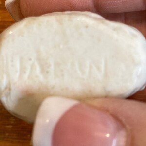 May include: Close-up of a white ceramic object with the word "JAPAN" embossed on the surface.