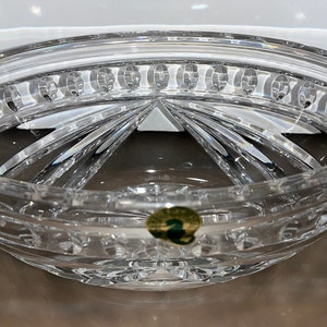 Puede incluir: Un cuenco de cristal transparente con un dise&ntilde;o de cristal tallado. El cuenco tiene una forma redonda y un borde ancho. El cuenco est&aacute; decorado con una pegatina verde con el n&uacute;mero "2" en ella.