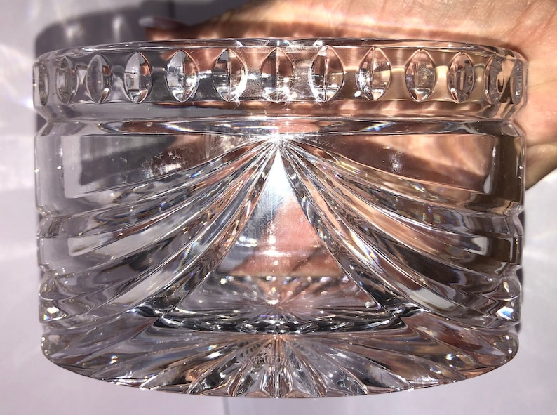 May include: A clear glass bowl with a decorative, cut-glass design. The bowl has a scalloped rim and a starburst pattern at the base.