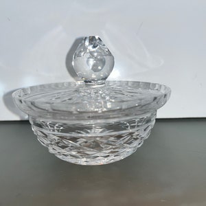 May include: A clear glass sugar bowl with a lid. The bowl has a cut glass design and the lid has a knob.
