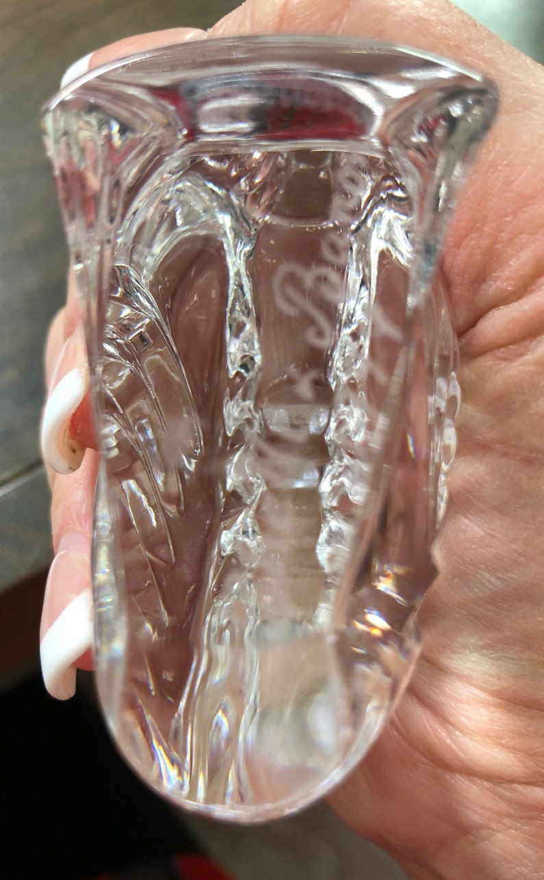 Peut inclure: Un bouchon de bouteille en verre transparent avec un design d&eacute;coratif. Le bouchon est grav&eacute; avec le texte "Baccarat France".