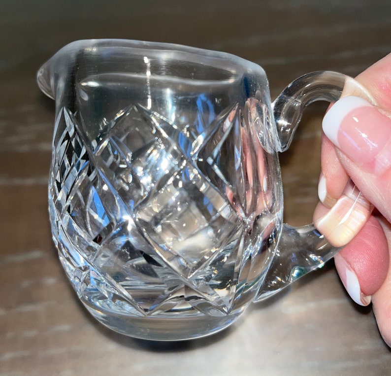 Peut inclure: Une cr&eacute;mier en verre transparent avec un motif en verre taill&eacute;. La cr&eacute;mier a une poign&eacute;e et un corps arrondi.