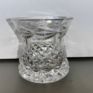 May include: A clear glass shot glass with a diamond pattern.