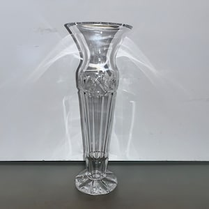 May include: A clear glass vase with a cut crystal design. The vase has a wide mouth and a narrow base.