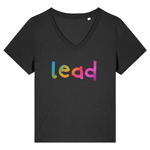 May include: Black V-neck t-shirt with the word "lead" in a rainbow gradient across the chest. The word is in a distressed font. The shirt has short sleeves and a classic fit.
