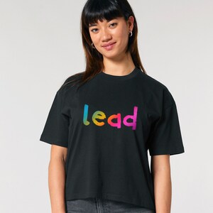 May include: A black cropped t-shirt with a rainbow gradient "lead" graphic.