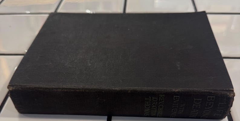 May include: A vintage hardcover book with a black cover. The book's spine displays the title "Life Beyond Death With Evidence" and the author's name. The book is rectangular and appears to be well-worn, with visible signs of age.