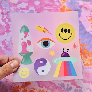 May include: A pink sheet of paper with various colorful stickers. The stickers include a lava lamp, a smiley face, an eye, a UFO, a yin yang symbol, a star, and a lightning bolt.