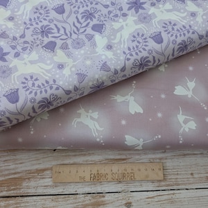 May include: Two fabric samples featuring a fantasy design. One is lavender with white unicorns, fairies, and floral patterns. The other is a lighter mauve with similar white imagery. A wooden ruler with the text "THE FABRIC SQUIRREL" is at the bottom.