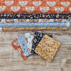 May include: A set of six fabric panels featuring a woodland animal print with squirrels, acorns, and leaves in shades of brown, blue, yellow, and white. The fabric panels are arranged in a stack on a wooden surface.
