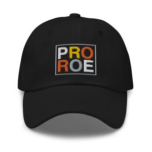 Könnte beinhalten: Schwarze Baseballkappe mit einem gestickten quadratischen Patch, auf dem "PRO ROE" in gelben, orangefarbenen und grauen Buchstaben steht.