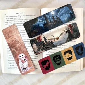 May include: Set of five Harry Potter-themed bookmarks. One bookmark features a Hogwarts castle scene under a moonlit sky. Another shows a golden snitch. The remaining bookmarks display the Hogwarts house crests and an owl.