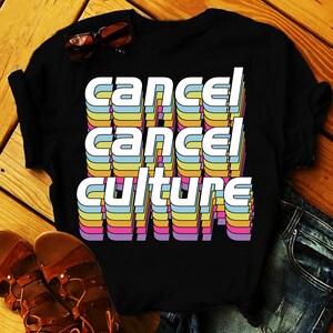 May include: Black t-shirt with the text "cancel cancel culture" in rainbow coloured letters.