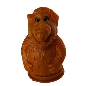 May include: A brown plastic figurine of a furry creature with a long nose and large eyes. The figurine is a popular character from a classic television show.
