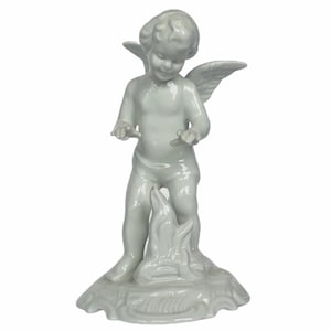 Könnte beinhalten: Eine weiße Porzellanfigur eines Engels mit Flügeln, stehend auf einem strukturierten Sockel. Der Engel lächelt und streckt die Hände aus. Ein dekorativer Artikel.