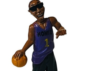 May include: A purple and black basketball jersey with the word "HOMIE" and the number "1" on the front. The figure is wearing sunglasses and holding a basketball.