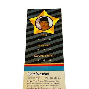 May include: A wrestling trading card featuring Ricky "The Dragon" Steamboat. The card has a yellow star with a photo of Steamboat in the center. The card lists his height as 6'0" and his weight as 240 lbs. The card also lists his favorite hold as the Flying Body Press.