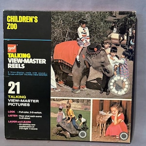 May include: A vintage GAF Children's Zoo Talking View-Master Reels box set. The box shows children with an elephant and other zoo scenes. The box reads "21 Talking View-Master Pictures" and includes the text "Look - Full colour, 3-D realism."