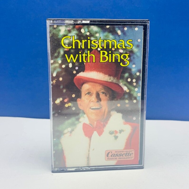 May include: A cassette tape featuring a picture of Bing Crosby dressed as Santa Claus. The tape is titled "Christmas with Bing".