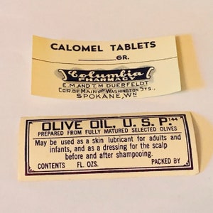 May include: Two vintage labels, one for Calomel Tablets from Columbia Pharmacy in Spokane, Washington, and the other for Olive Oil, U.S.P. 144, prepared from fully matured selected olives. The olive oil label states that it can be used as a skin lubricant for adults and infants, and as a dressing for the scalp before and after shampooing.