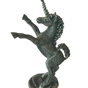May include: A pewter figurine of a rearing unicorn with a spiral horn. The unicorn is standing on a circular base.