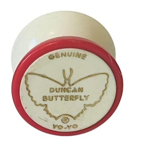 May include: A white yo-yo with a red rim and a gold butterfly design. The yo-yo has the text "GENUINE DUNCAN BUTTERFLY YO-YO" printed on it.
