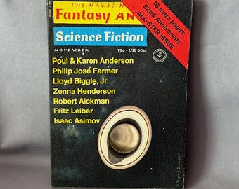 May include: A vintage magazine cover for "Fantasy and Science Fiction" from November. The cover features a dark background with a planetary design and the names of authors. A red banner indicates the 22nd Anniversary All-Star Issue with 16 extra pages.