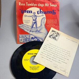 May include: Vintage record album cover for "Tom Thumb" featuring Russ Tamblyn, with a red and blue design. Includes a black vinyl record and a handwritten letter. The album cover has the text "Russ Tamblyn sings Hit Songs".