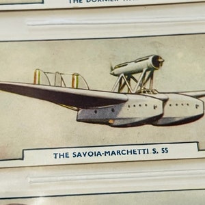 May include: A black and white illustration of a Savoia-Marchetti S.55 seaplane. The plane has a long, narrow fuselage and two large floats. The plane is flying over a body of water.