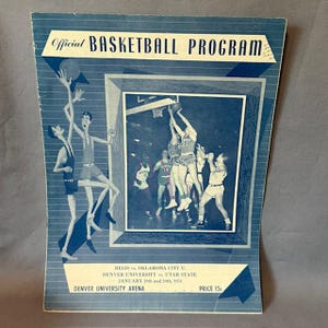 Könnte beinhalten: Vintage Basketball-Programm mit blau-weißem Design. Das Cover zeigt Illustrationen von Basketballspielern in Aktion. Der Text enthält "Official Basketball Program" und Spielinformationen.