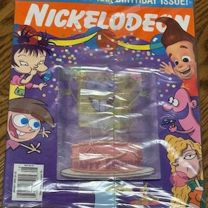 May include: A Nickelodeon magazine cover featuring cartoon characters and the text "IT'S OUR TASTY 10th BIRTHDAY ISSUE!" The cover has a purple background with images of SpongeBob SquarePants and a pink cake.