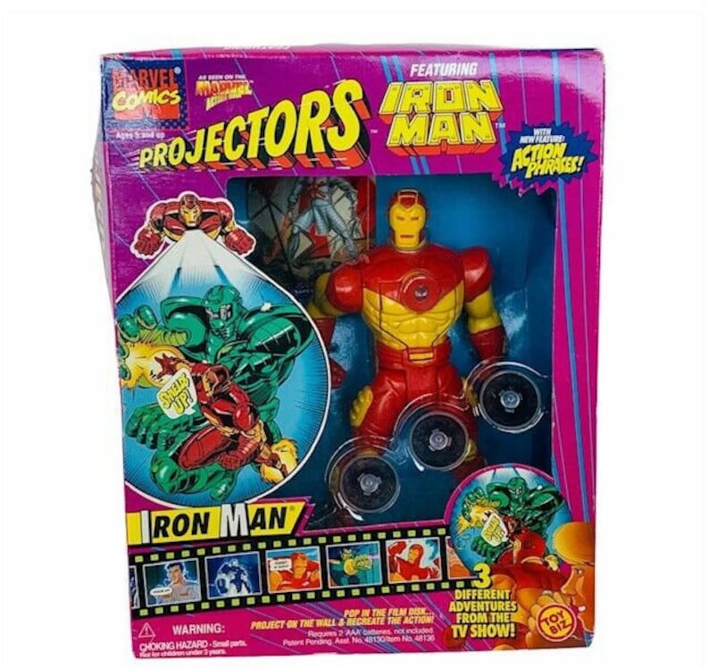 K&ouml;nnte beinhalten: Eine rote und gelbe Iron Man Actionfigur mit einer Projektionsscheibe. Die Verpackung zeigt das Marvel Comics Logo und die Worte "Projectors Iron Man" mit dem Satz "Neue Funktion Action-S&auml;tze!" Die Verpackung zeigt auch Bilder von Iron Man in verschiedenen Posen.
