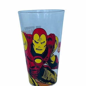 May include: A clear glass with a red and yellow Iron Man graphic. The graphic shows Iron Man in a fighting pose with the text "The Invincible Iron Man" on the glass.
