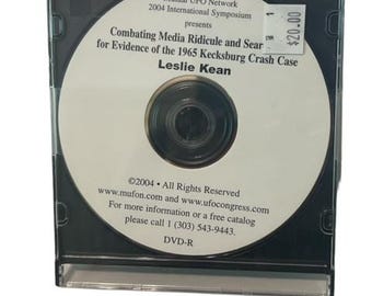 Puede incluir: Un disco DVD-R en una caja negra con el título "Combating Media Ridicule and Search for Evidence of the 1965 Kecksburg Crash Case" de Leslie Kean. El disco es una presentación del Simposio Internacional 2004 de la Red Mutual de Objetos Voladores No Identificados (Mutual UFO Network). El precio es de 20,00 €.