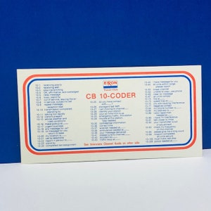 May include: A rectangular CB 10-Coder card from Exxon Travel Club, featuring a red and blue border. The card lists CB radio codes, including phrases like "receiving poorly" and "urgent business."