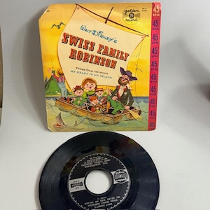 May include: A vintage 45 RPM record and sleeve for Walt Disney's "Swiss Family Robinson." The sleeve features a colorful illustration of the family in a boat, with the text "My Heart Is An Island." The record is black with a white label.