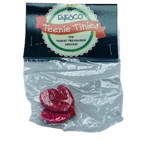 Könnte beinhalten: Eine Packung mit zwei roten herzförmigen Ornamenten mit einer goldenen Schnur zum Aufhängen. Die Verpackung ist mit "Enesco Teenie Tiniest Treasures Around" beschriftet.